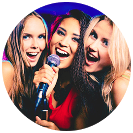 Three women are singing into a microphone.